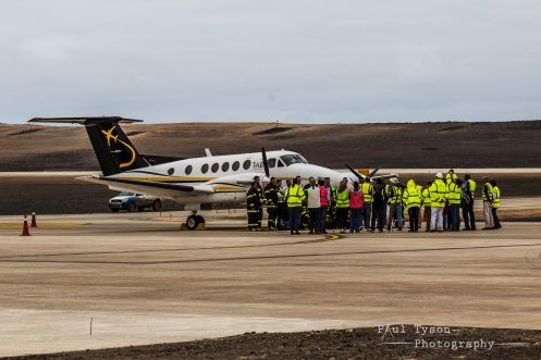 Dignitaries, staff and others gathered around the plane and crew.